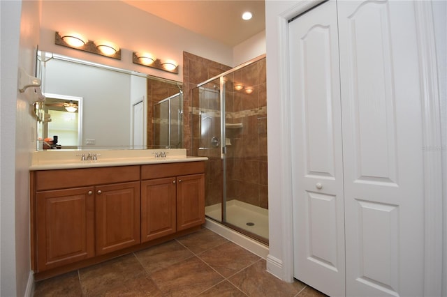 bathroom with oversized vanity, tile flooring, walk in shower, and double sink