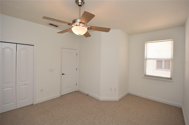 unfurnished bedroom with a closet, ceiling fan, and light colored carpet