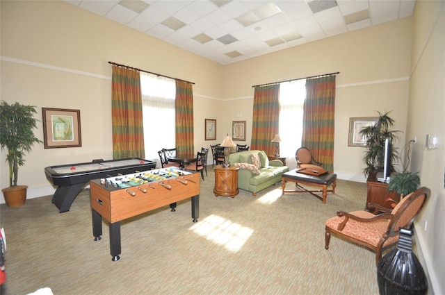 game room featuring light carpet, a paneled ceiling, a towering ceiling, and crown molding