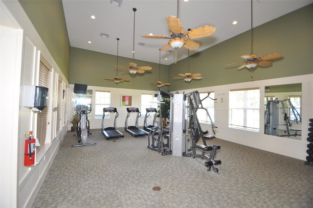 workout area with a high ceiling, carpet flooring, and ceiling fan