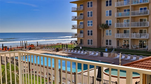 view of pool featuring a patio area and a water view