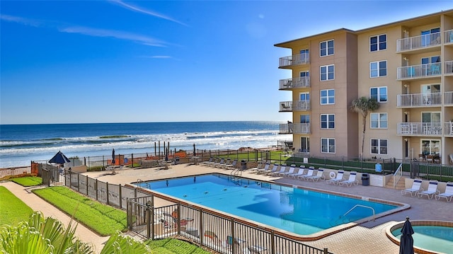 view of pool with a patio and a water view