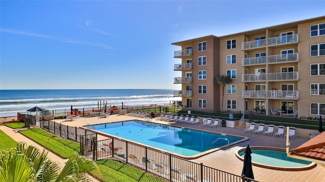 view of swimming pool featuring a water view and a patio