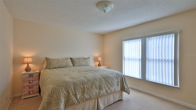 tiled bedroom with a textured ceiling and multiple windows