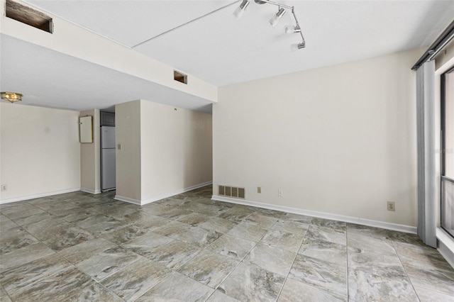 spare room with light tile floors and track lighting