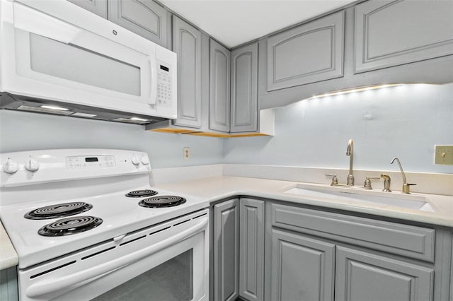 kitchen with range, sink, and gray cabinets