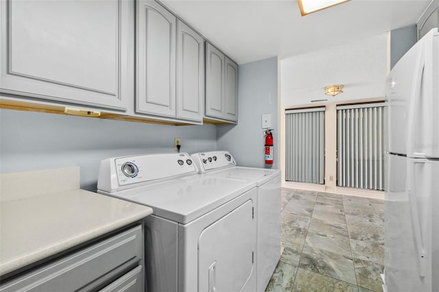 washroom with cabinets, independent washer and dryer, and light tile floors