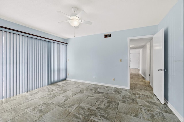 empty room featuring dark tile floors and ceiling fan