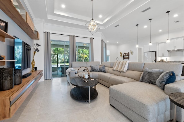 living room with an inviting chandelier, crown molding, a tray ceiling, and light tile floors