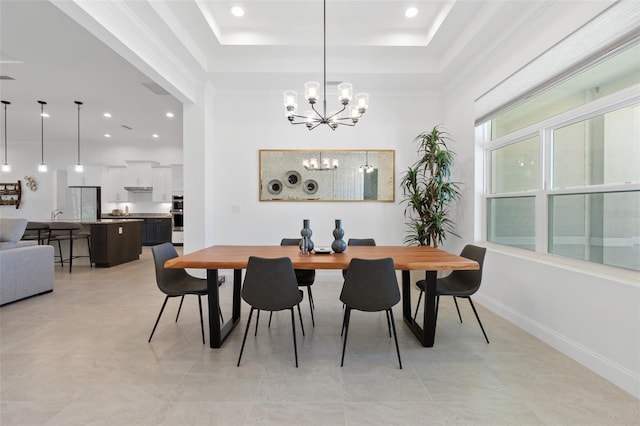 dining room featuring an inviting chandelier, light tile floors, and a tray ceiling