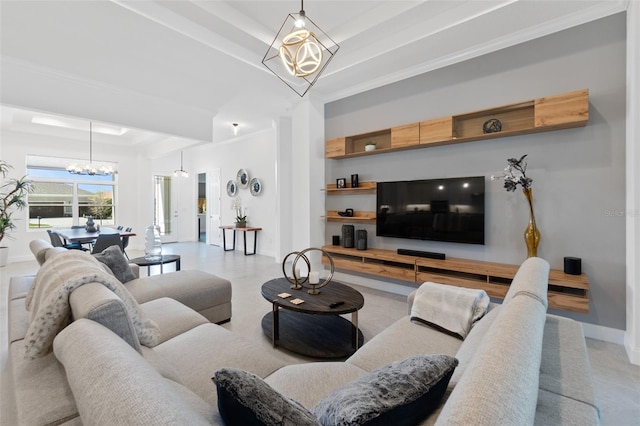 living room featuring a chandelier, a raised ceiling, light tile floors, and crown molding