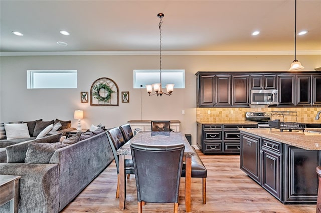 kitchen featuring decorative light fixtures, a chandelier, light hardwood / wood-style floors, and stainless steel appliances