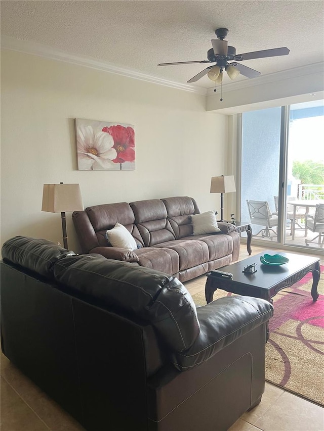 living room with ceiling fan, ornamental molding, and a textured ceiling