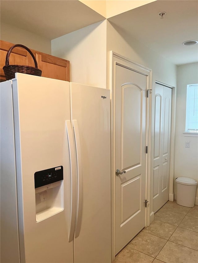 kitchen featuring white refrigerator with ice dispenser and light tile patterned floors