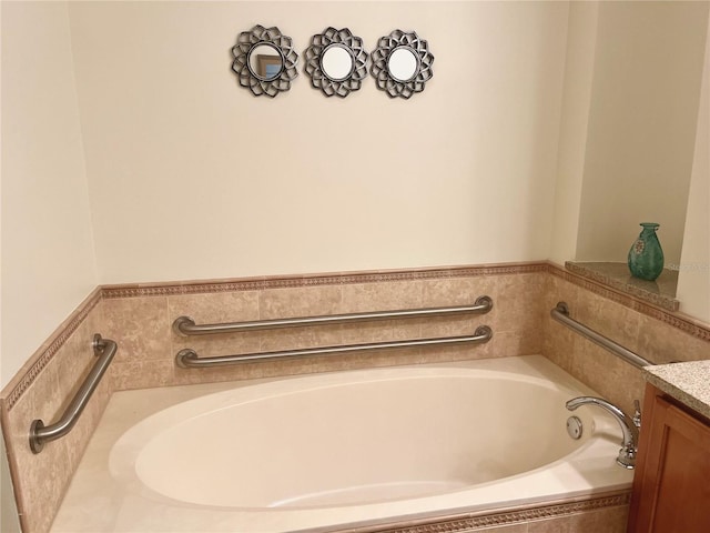 bathroom with vanity and tiled tub