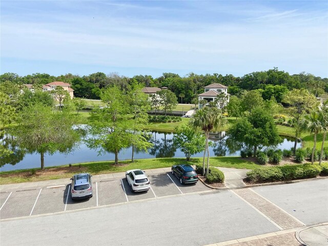 view of car parking featuring a water view