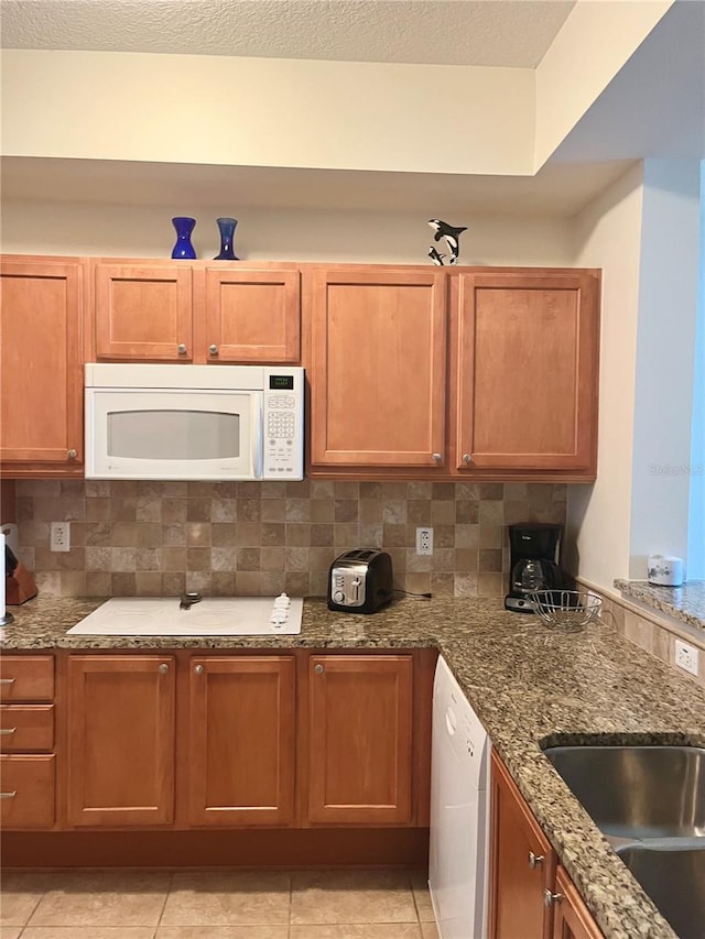 kitchen featuring tasteful backsplash, sink, white appliances, and light tile patterned floors