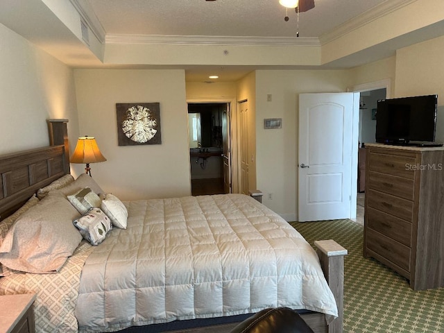 bedroom with crown molding, a tray ceiling, a textured ceiling, and carpet flooring