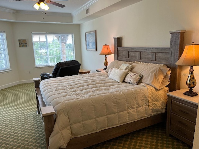 carpeted bedroom with a raised ceiling, ornamental molding, and ceiling fan