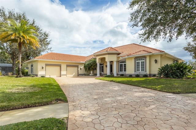 mediterranean / spanish house with a front lawn and a garage