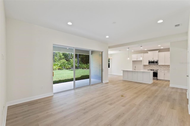 unfurnished living room with light wood-type flooring and sink