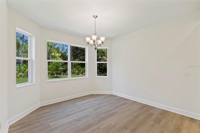 empty room featuring light hardwood / wood-style floors and a chandelier