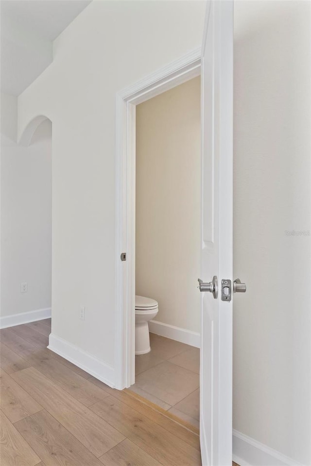 bathroom featuring wood-type flooring and toilet