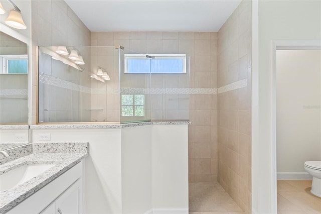 bathroom featuring tile patterned floors, tiled shower, vanity, and toilet