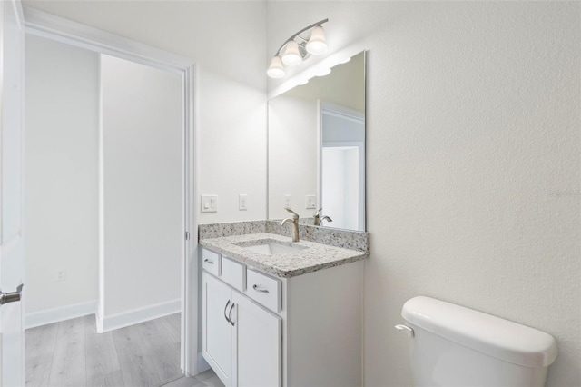 bathroom featuring vanity, toilet, and hardwood / wood-style flooring