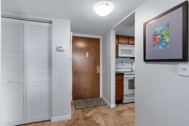 kitchen featuring light tile floors and white appliances