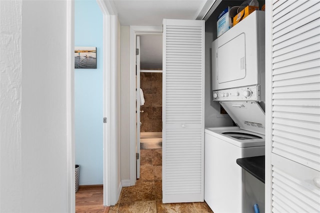 laundry room featuring stacked washer / dryer and light tile flooring