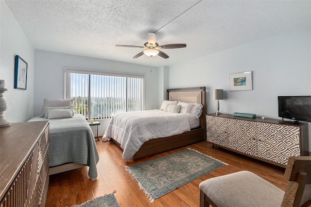 bedroom with a textured ceiling, ceiling fan, and hardwood / wood-style flooring