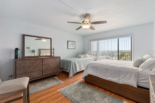 bedroom featuring light hardwood / wood-style floors, a textured ceiling, access to exterior, and ceiling fan