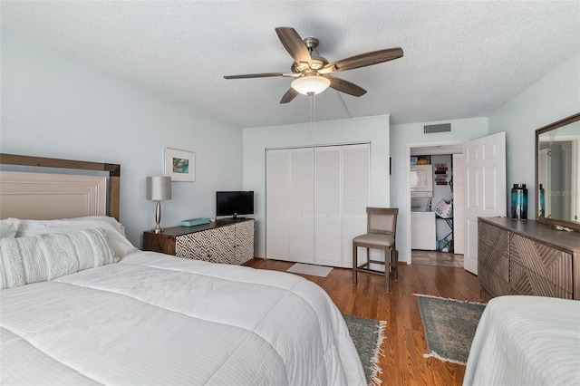 bedroom with dark hardwood / wood-style floors, a textured ceiling, a closet, and ceiling fan