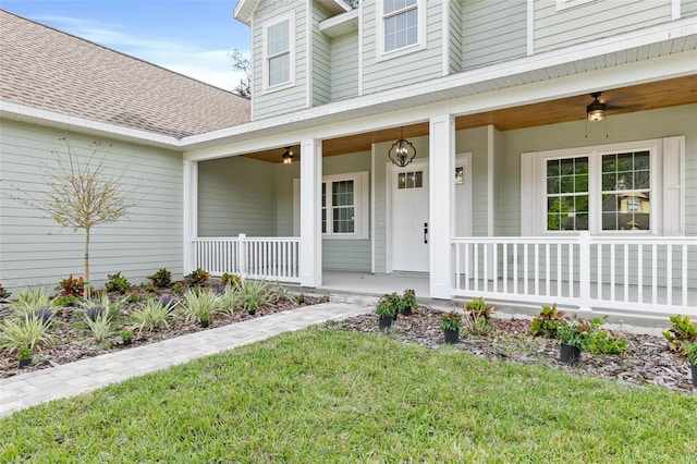 property entrance with covered porch, ceiling fan, and a lawn