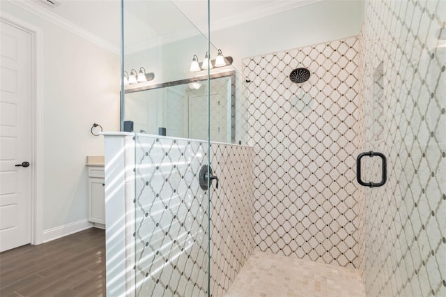 bathroom featuring hardwood / wood-style flooring, a shower with shower door, vanity, and ornamental molding