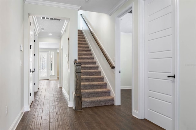 staircase featuring crown molding, a textured ceiling, and hardwood / wood-style flooring