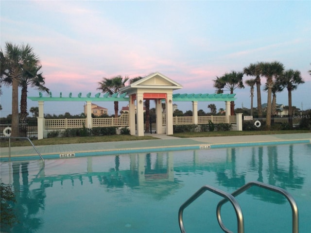 pool at dusk with a pergola