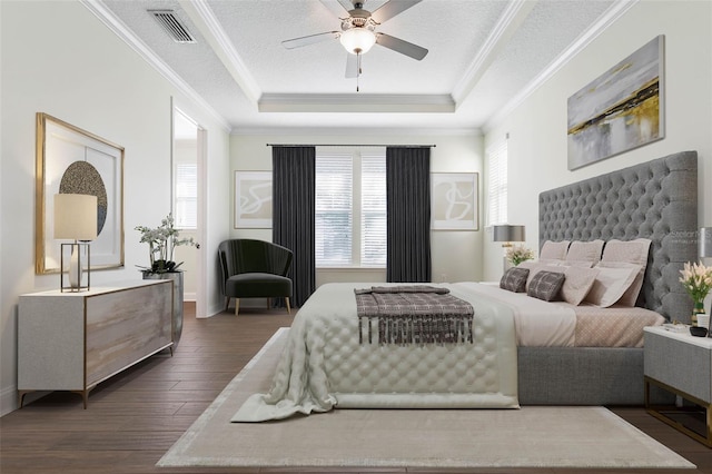 bedroom featuring ceiling fan, a textured ceiling, dark hardwood / wood-style flooring, and a raised ceiling