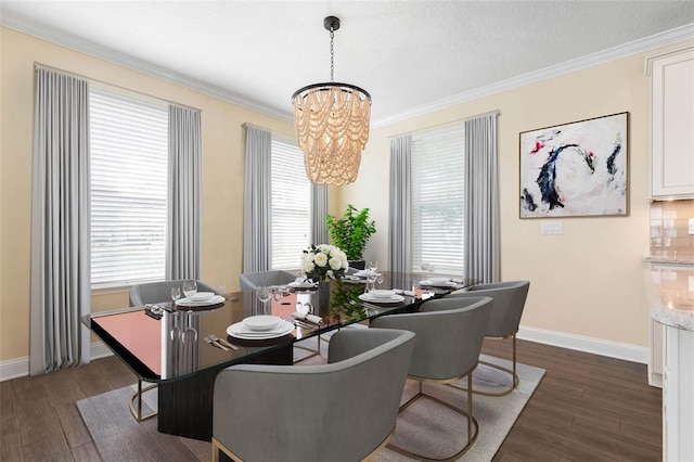 dining space featuring a textured ceiling, dark wood-type flooring, a chandelier, and ornamental molding