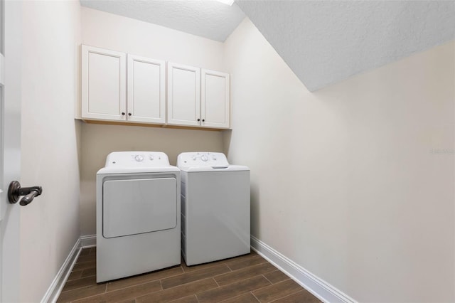 laundry area featuring a textured ceiling, cabinets, and washing machine and clothes dryer