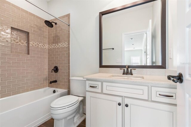 full bathroom featuring toilet, tiled shower / bath combo, and vanity