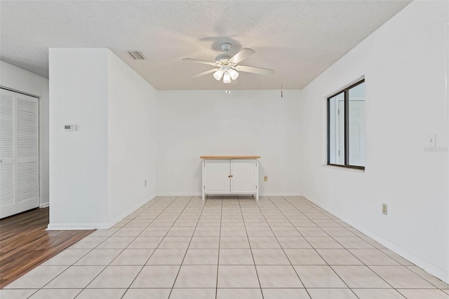 unfurnished room featuring light tile floors, ceiling fan, and a textured ceiling