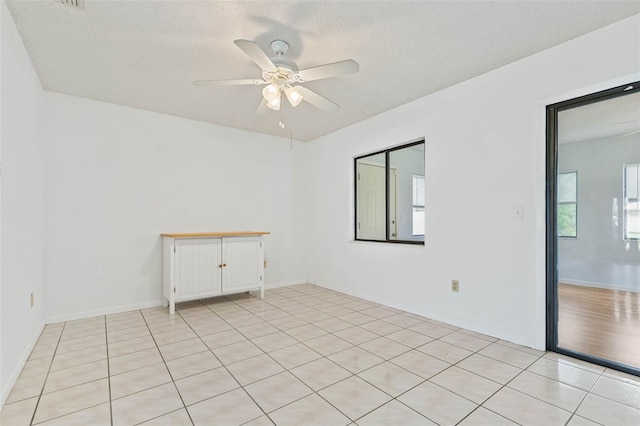 tiled spare room featuring a textured ceiling and ceiling fan