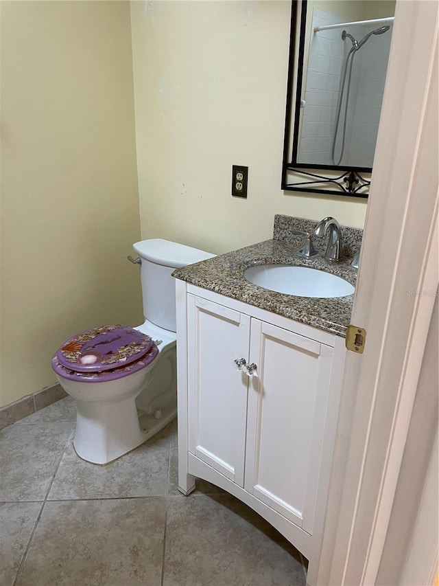 bathroom with tiled shower, vanity, toilet, and tile patterned flooring