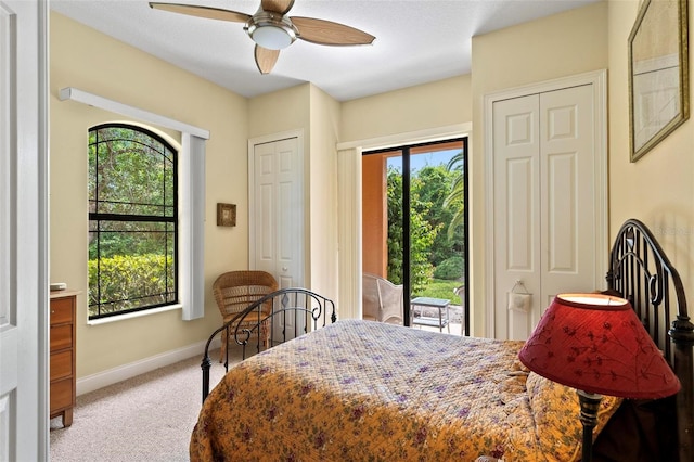 carpeted bedroom with multiple windows, access to exterior, ceiling fan, and multiple closets