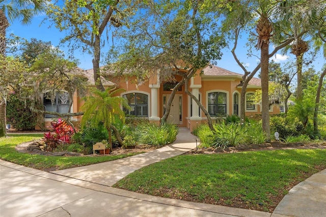 mediterranean / spanish-style house with a front yard