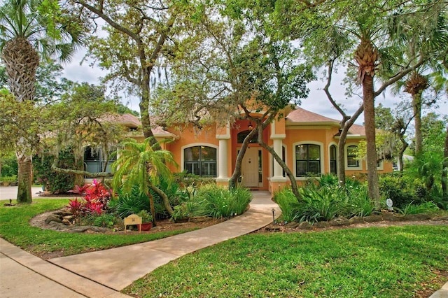 mediterranean / spanish-style house featuring a front yard