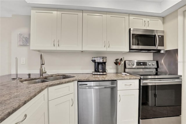 kitchen with sink, appliances with stainless steel finishes, and white cabinets