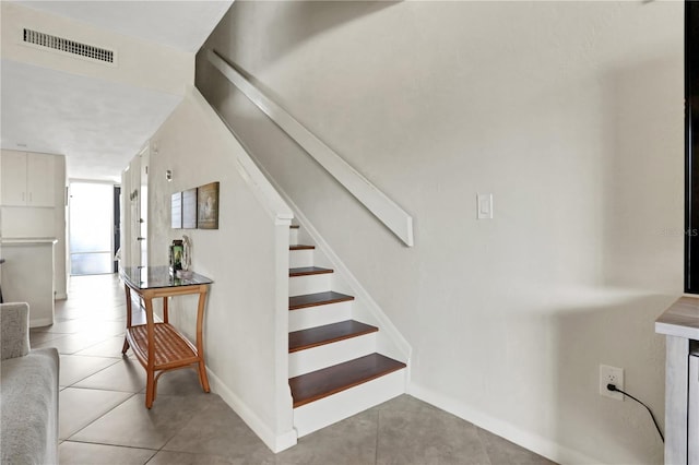 stairway featuring tile patterned flooring